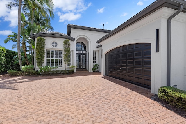 16284 Via Venetia W, Delray Beach, FL 33484 - view of front of house featuring decorative driveway, french doors, an attached garage, and stucco siding