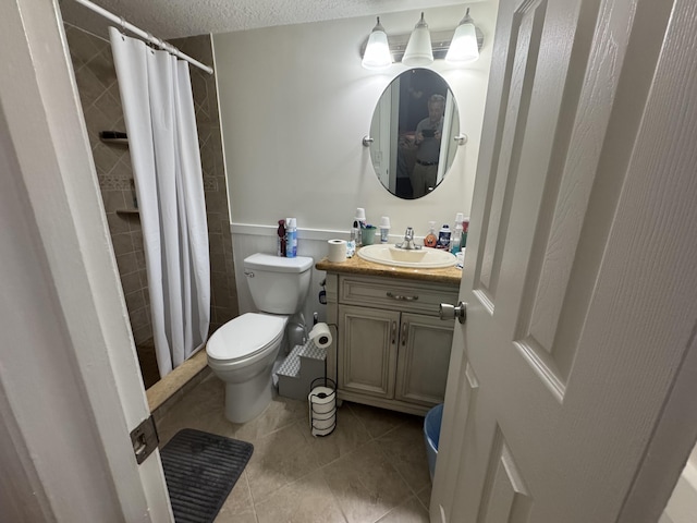 117 Lake Pine Cir Unit C-1, Greenacres, FL 33463 - full bath with vanity, tile patterned flooring, a tile shower, a textured ceiling, and a wainscoted wall