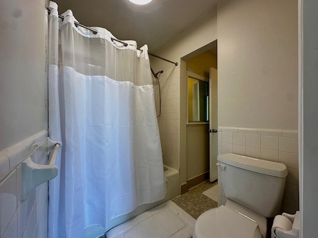 148 Yacht Club Dr Unit 13, North Palm Beach, FL 33408 - bathroom with shower / tub combo, tile patterned floors, tile walls, and a wainscoted wall