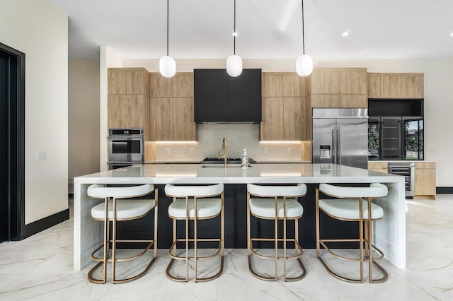 13480 US Highway 1, Juno Beach, FL 33408 - kitchen featuring appliances with stainless steel finishes, wine cooler, backsplash, a large island with sink, and light countertops