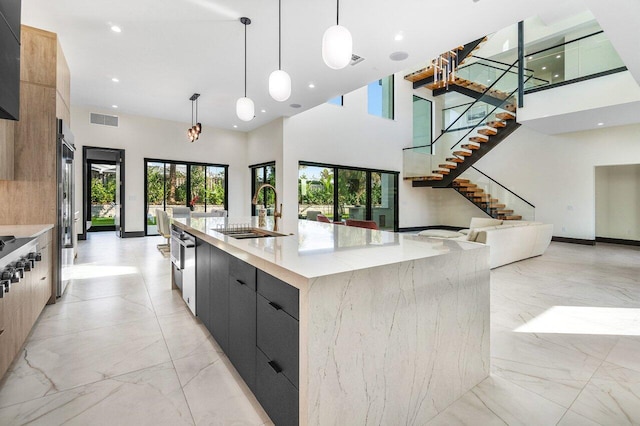 13480 US Highway 1, Juno Beach, FL 33408 - kitchen with modern cabinets, open floor plan, a large island, light marble finish floors, and a high ceiling