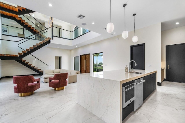 13480 US Highway 1, Juno Beach, FL 33408 - kitchen featuring modern cabinets, light marble finish floors, stainless steel dishwasher, a towering ceiling, and a large island with sink