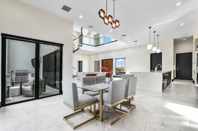 13480 US Highway 1, Juno Beach, FL 33408 - dining space with light marble finish floors, a chandelier, a towering ceiling, and recessed lighting
