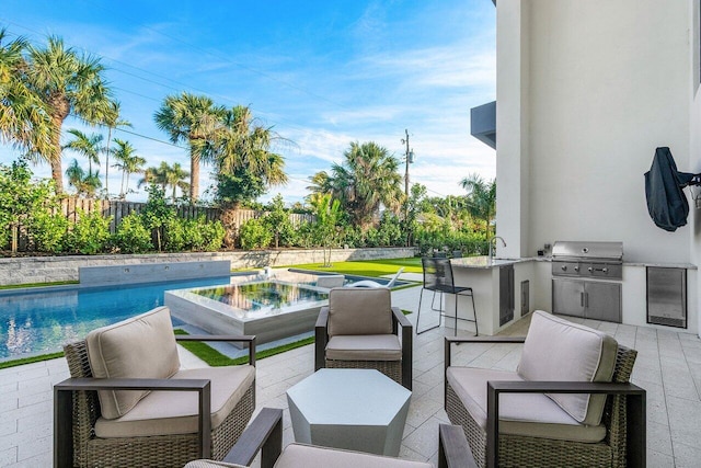 13480 US Highway 1, Juno Beach, FL 33408 - fenced backyard with an outdoor kitchen, a patio, and a pool with connected hot tub