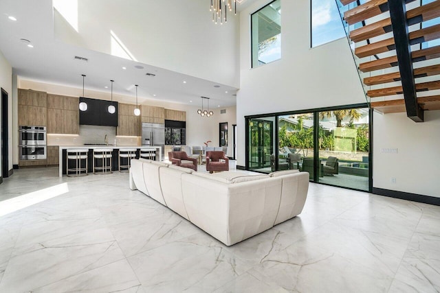 13480 US Highway 1, Juno Beach, FL 33408 - living area with a chandelier, light marble finish floors, a high ceiling, and recessed lighting