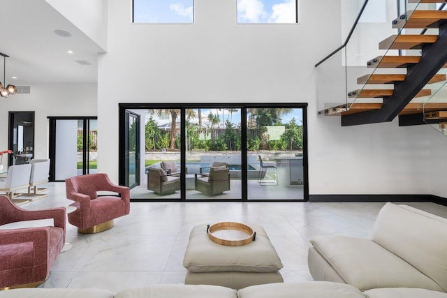 13480 US Highway 1, Juno Beach, FL 33408 - living room with a towering ceiling, stairway, marble finish flooring, a chandelier, and recessed lighting