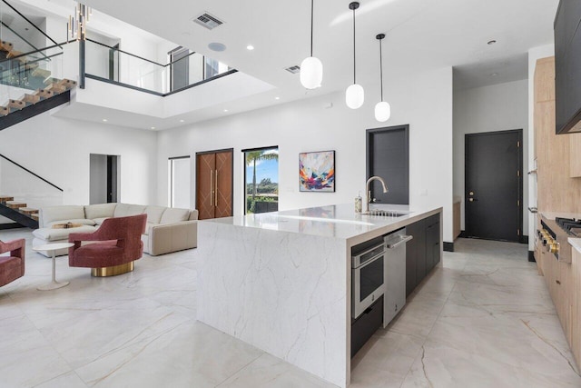 13480 US Highway 1, Juno Beach, FL 33408 - kitchen featuring modern cabinets, a high ceiling, a large island, light marble finish flooring, and light stone counters