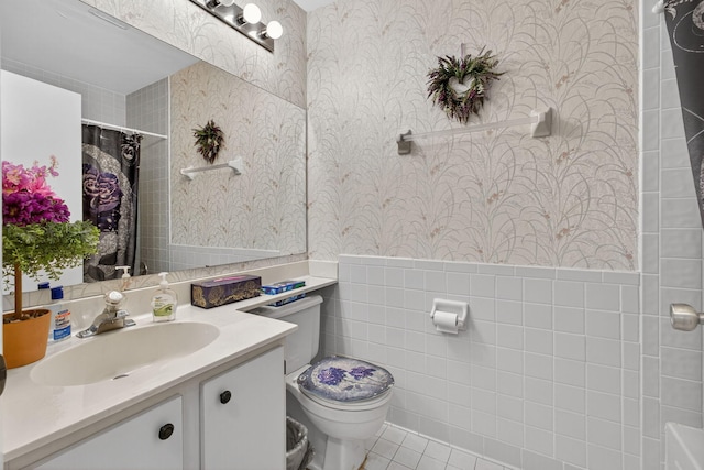 2640 Gately Dr W Unit 1604, West Palm Beach, FL 33415 - full bath featuring wallpapered walls, vanity, tile walls, tile patterned floors, and wainscoting