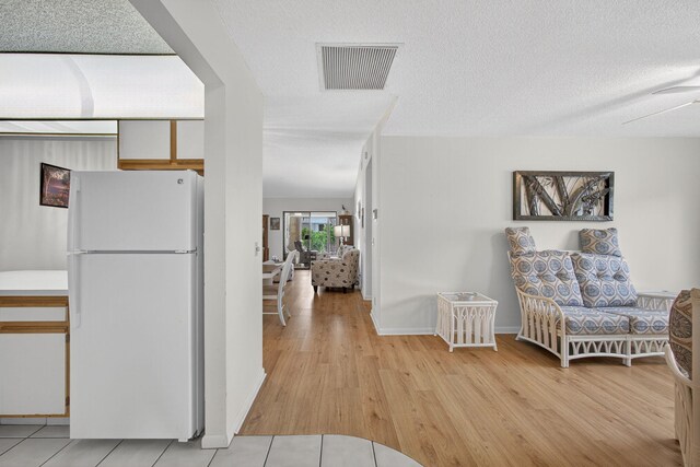 2640 Gately Dr W Unit 1604, West Palm Beach, FL 33415 - kitchen with freestanding refrigerator, light wood-style flooring, and a textured ceiling
