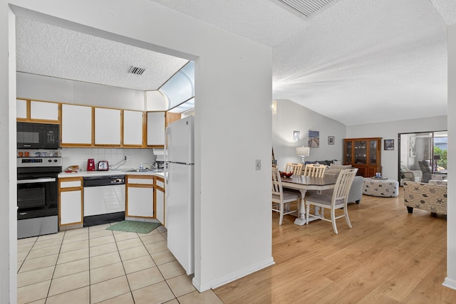 2640 Gately Dr W Unit 1604, West Palm Beach, FL 33415 - kitchen with white appliances, a textured ceiling, light countertops, open floor plan, and light wood-style flooring