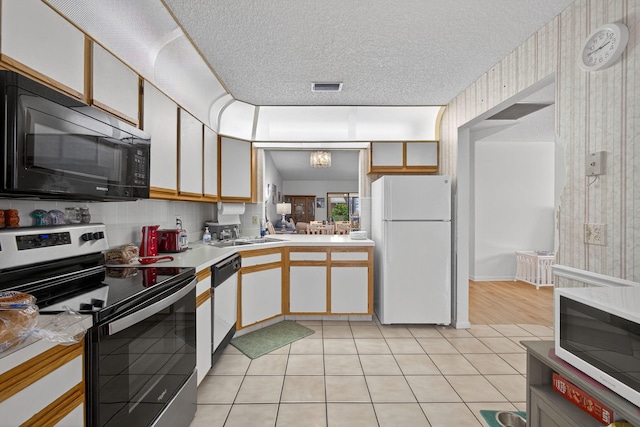 2640 Gately Dr W Unit 1604, West Palm Beach, FL 33415 - kitchen featuring white appliances, light countertops, light tile patterned floors, and a textured ceiling