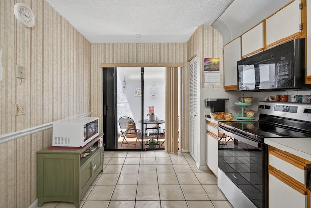 2640 Gately Dr W Unit 1604, West Palm Beach, FL 33415 - kitchen with black microwave, stainless steel range with electric cooktop, wallpapered walls, white microwave, and light countertops