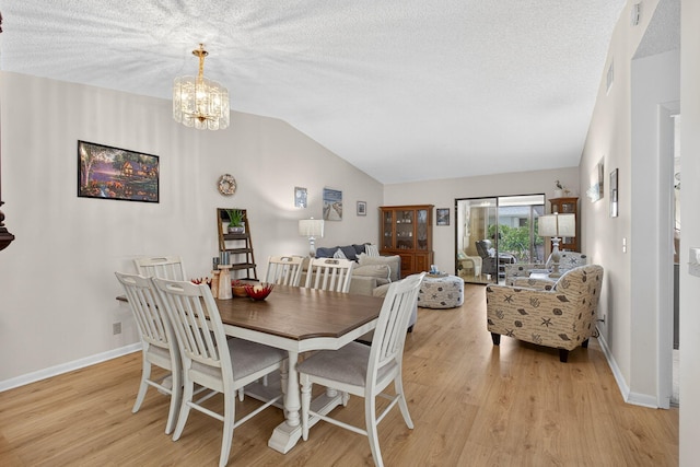 2640 Gately Dr W Unit 1604, West Palm Beach, FL 33415 - dining room featuring lofted ceiling, light wood-style flooring, a chandelier, and a textured ceiling