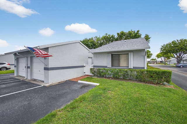 2640 Gately Dr W Unit 1604, West Palm Beach, FL 33415 - view of home's exterior featuring stucco siding and a lawn