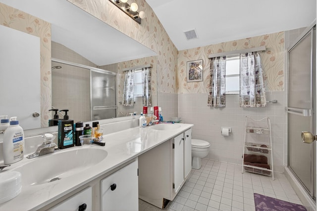 2640 Gately Dr W Unit 1604, West Palm Beach, FL 33415 - bathroom with wallpapered walls, tile walls, tile patterned floors, a shower stall, and double vanity