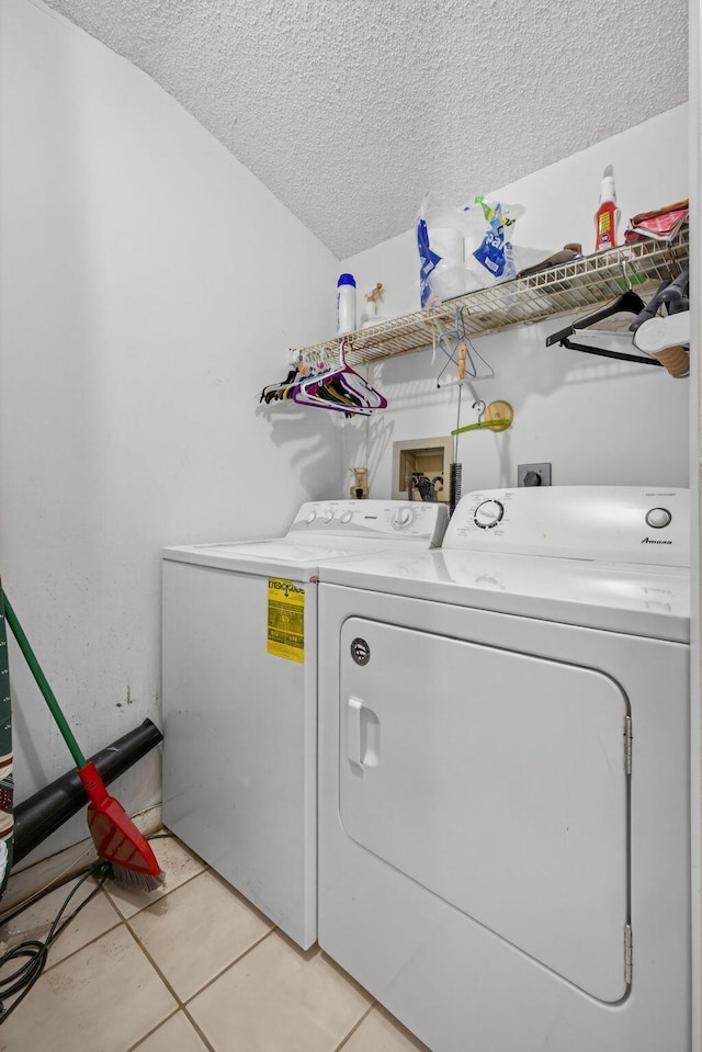 2640 Gately Dr W Unit 1604, West Palm Beach, FL 33415 - washroom featuring washer and dryer, a textured ceiling, and light tile patterned floors