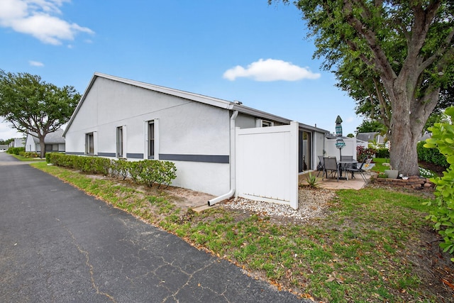 2640 Gately Dr W Unit 1604, West Palm Beach, FL 33415 - view of side of home featuring a patio area and stucco siding