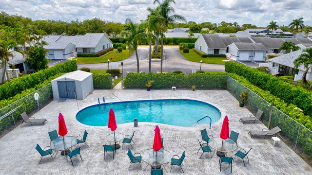 2640 Gately Dr W Unit 1604, West Palm Beach, FL 33415 - community pool featuring a residential view, a shed, and a patio