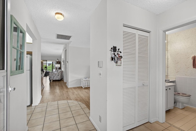 2640 Gately Dr W Unit 1604, West Palm Beach, FL 33415 - hall featuring a textured ceiling and light tile patterned floors