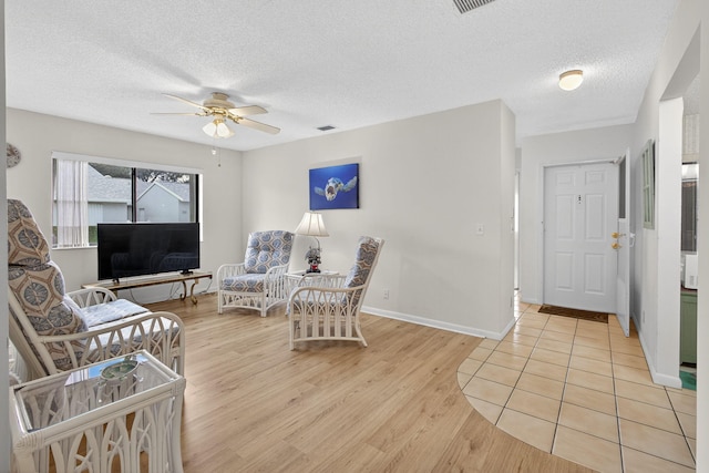 2640 Gately Dr W Unit 1604, West Palm Beach, FL 33415 - living room featuring ceiling fan, light wood-style floors, and a textured ceiling