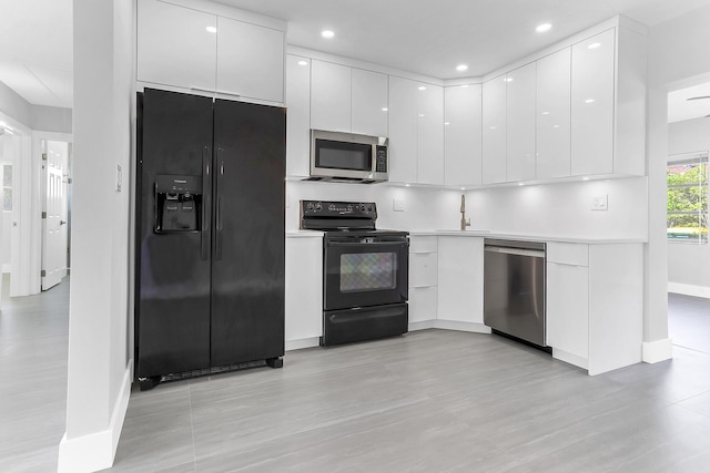 7609 NW 70th Ave, Tamarac, FL 33321 - kitchen with black appliances, modern cabinets, white cabinetry, light wood finished floors, and recessed lighting