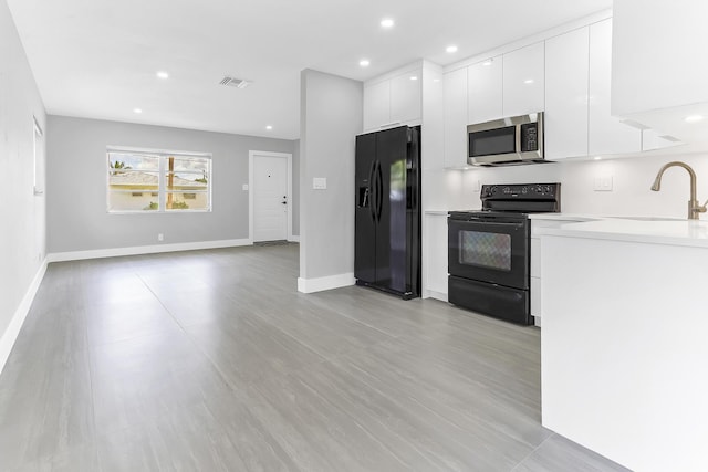 7609 NW 70th Ave, Tamarac, FL 33321 - kitchen featuring black appliances, modern cabinets, white cabinets, light countertops, and recessed lighting