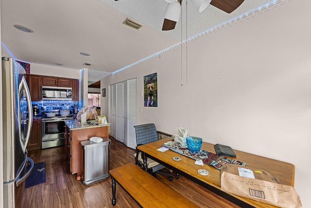5310 Pebble Beach Dr Unit F, Orlando, FL 32811 - kitchen with appliances with stainless steel finishes, a center island, dark wood-style floors, ceiling fan, and backsplash