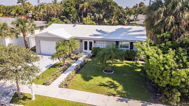 8 Wellesley Dr, Lake Worth Beach, FL 33460 - ranch-style house with french doors, a tile roof, an attached garage, and a front yard