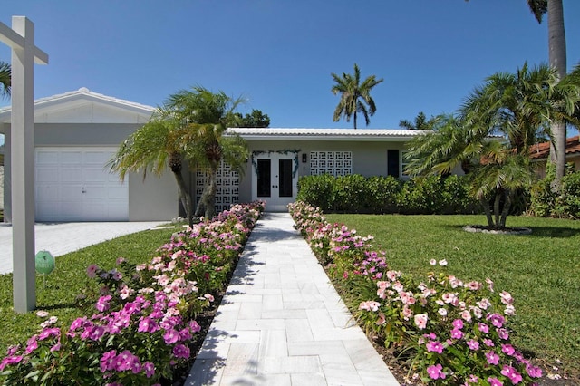 8 Wellesley Dr, Lake Worth Beach, FL 33460 - ranch-style house with french doors, an attached garage, a front yard, driveway, and stucco siding