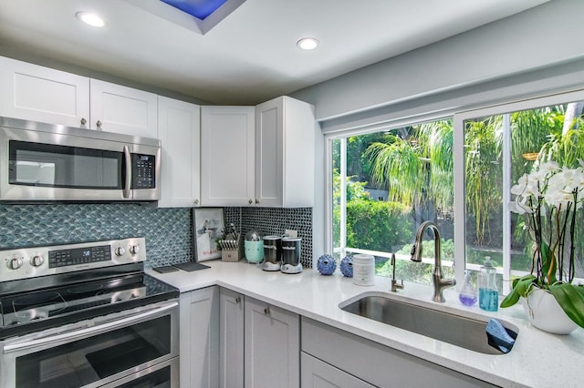 8 Wellesley Dr, Lake Worth Beach, FL 33460 - kitchen with stainless steel appliances, tasteful backsplash, white cabinets, and recessed lighting