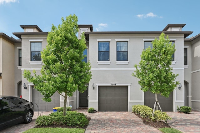 2808 Troubadour St, Palm Springs, FL 33406 - townhome / multi-family property with a garage, stucco siding, and driveway