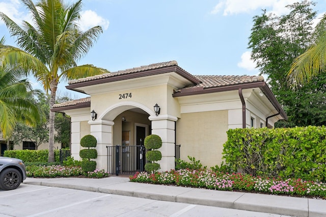 2808 Troubadour St, Palm Springs, FL 33406 - view of front of home with a tile roof, a gate, and stucco siding