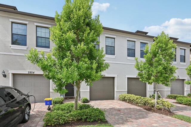 2808 Troubadour St, Palm Springs, FL 33406 - townhome / multi-family property featuring stucco siding, driveway, and a garage