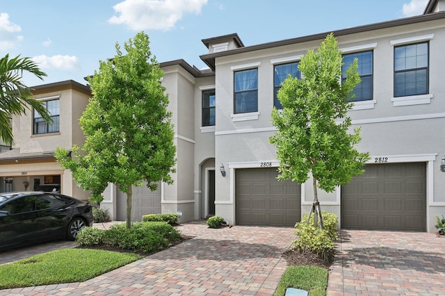 2808 Troubadour St, Palm Springs, FL 33406 - view of property with an attached garage, stucco siding, and driveway