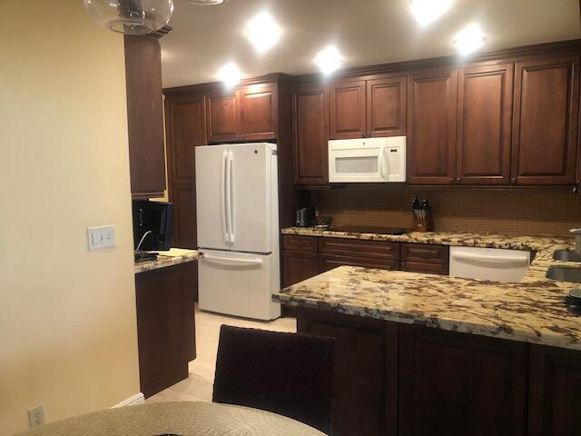 7992 Chula Vista Cres, Boca Raton, FL 33433 - kitchen with white appliances, light stone countertops, a peninsula, and tasteful backsplash