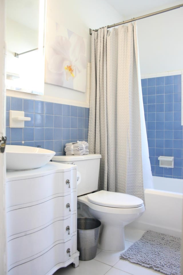 440 NE 1st Ave, Fort Lauderdale, FL 33301 - full bath with tile patterned floors, tile walls, vanity, shower / tub combo with curtain, and a wainscoted wall