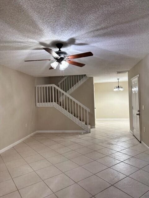 3310 33rd Way, West Palm Beach, FL 33407 - tiled spare room with a textured ceiling, a ceiling fan, and stairway