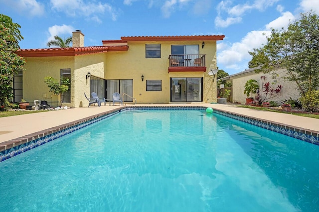 6526 Sweet Maple Ln, Boca Raton, FL 33433 - back of property with a balcony, a chimney, an outdoor pool, and stucco siding