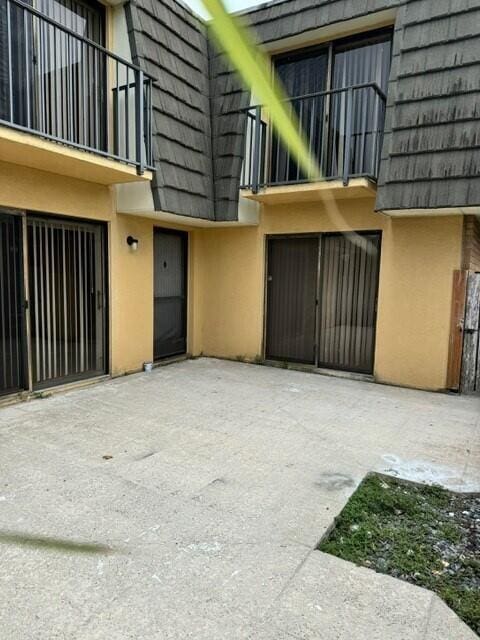3822 38th Way, West Palm Beach, FL 33407 - view of exterior entry featuring mansard roof, stucco siding, and a balcony