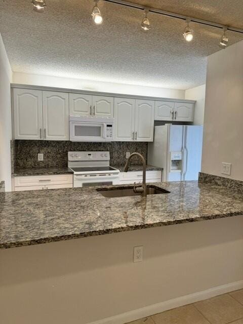 3822 38th Way, West Palm Beach, FL 33407 - kitchen featuring white appliances, dark stone counters, backsplash, and a textured ceiling
