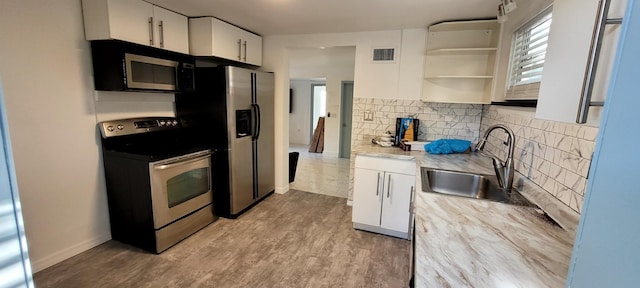 104 NE 5th St, Fort Lauderdale, FL 33301 - kitchen with stainless steel appliances, backsplash, white cabinetry, open shelves, and wood finished floors