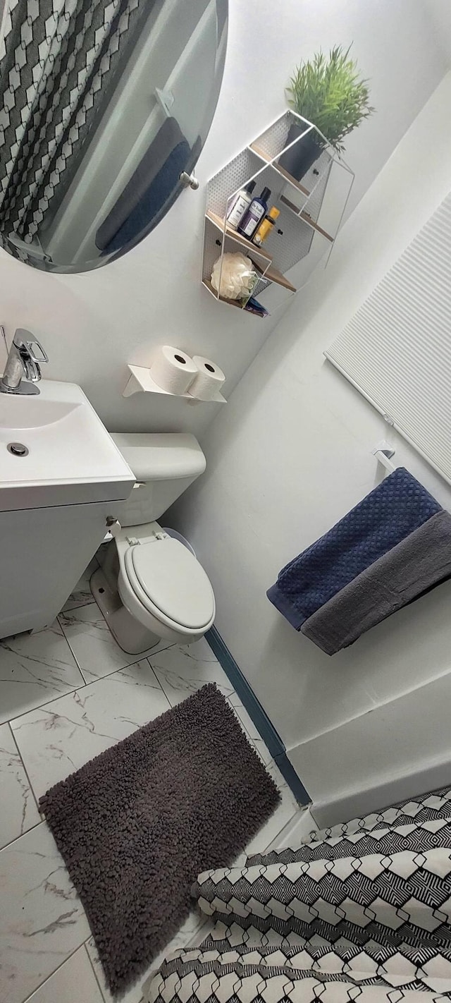 104 NE 5th St, Fort Lauderdale, FL 33301 - half bath featuring marble look tiles and toilet