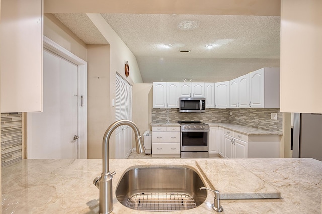 5330 NW 31st St, Margate, FL 33063 - kitchen featuring appliances with stainless steel finishes, backsplash, a textured ceiling, and white cabinets
