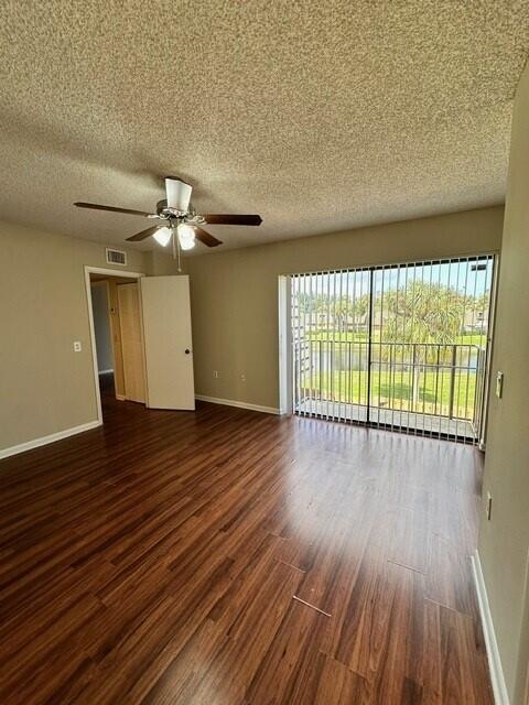 3819 38th Way, West Palm Beach, FL 33407 - unfurnished room featuring dark wood-type flooring, a ceiling fan, and a textured ceiling