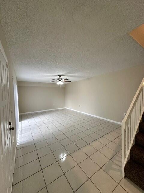 3819 38th Way, West Palm Beach, FL 33407 - unfurnished room featuring ceiling fan, light tile patterned floors, stairs, and a textured ceiling