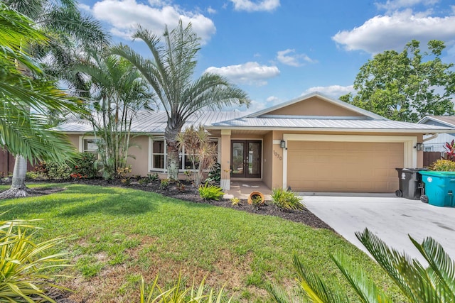 1070 SW Jennifer Ter, Port Saint Lucie, FL 34953 - ranch-style home featuring french doors, stucco siding, an attached garage, concrete driveway, and a front yard