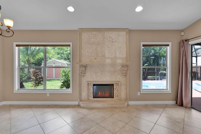 1070 SW Jennifer Ter, Port Saint Lucie, FL 34953 - unfurnished living room featuring a fireplace, light tile patterned flooring, recessed lighting, and a chandelier