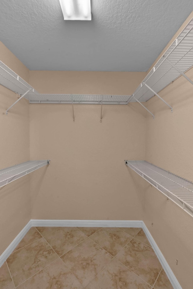 1070 SW Jennifer Ter, Port Saint Lucie, FL 34953 - walk in closet featuring light tile patterned floors