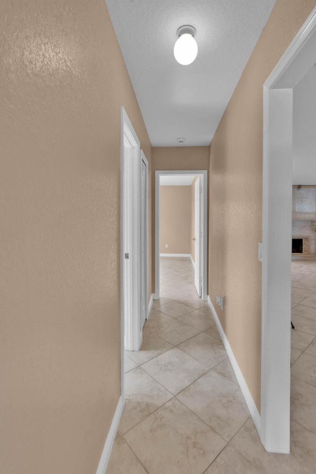 1070 SW Jennifer Ter, Port Saint Lucie, FL 34953 - corridor featuring a textured ceiling and light tile patterned flooring