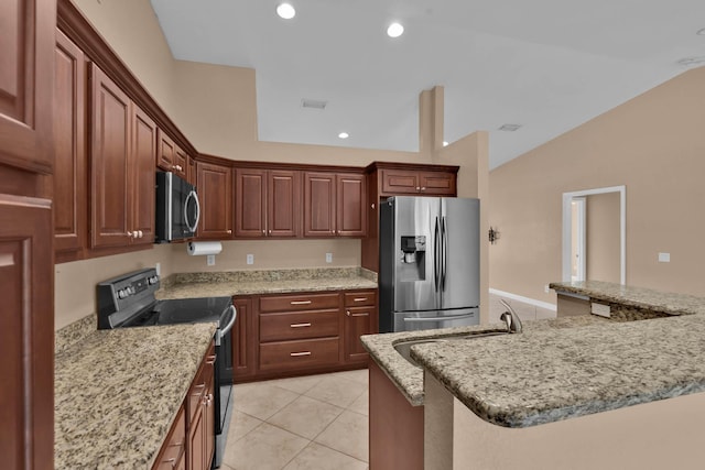 1070 SW Jennifer Ter, Port Saint Lucie, FL 34953 - kitchen featuring stainless steel appliances, light tile patterned floors, lofted ceiling, light stone countertops, and recessed lighting